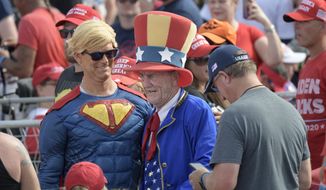 Supporters of President Donald Trump pose for photos while walking through the crowd during a campaign rally at the Ocala International Airport, Friday, Oct. 16, 2020, in Ocala, Fla. (AP Photo/Phelan M. Ebenhack)