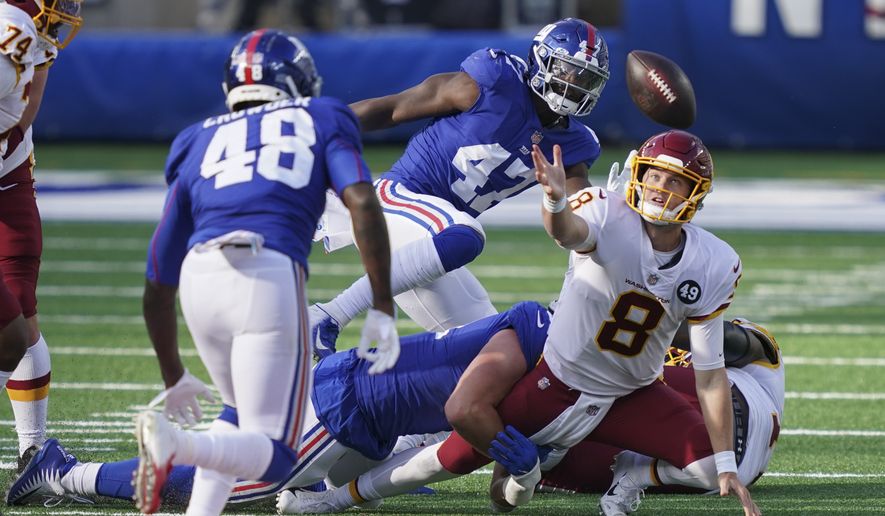 Washington Football Team quarterback Kyle Allen (8) loses control of the ball during the second half of an NFL football game Sunday, Oct. 18, 2020, in East Rutherford, N.J. New York Giants linebacker Tae Crowder (48) recovered the ball and scored a touchdown on the play. (AP Photo/John Minchillo)


