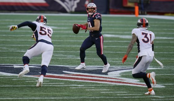 New England Patriots wide receiver Julian Edelman, center, looks for a receiver as he attempts to pass between Denver Broncos linebacker Bradley Chubb, left, and safety Justin Simmons, right, in the second half of an NFL football game, Sunday, Oct. 18, 2020, in Foxborough, Mass. (AP Photo/Charles Krupa)