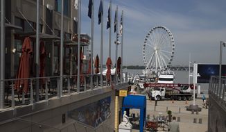 This photo taken May 20, 2014 shows the new &quot;Capital Wheel&quot; at National Harbor in Oxon Hill, Md. With a massive new Ferris wheel overlooking the nation’s capital, a children’s museum, a village of restaurants and hotels and a major casino resort on the horizon, National Harbor in Maryland has quickly become a travel alternative to the marble monuments and museums of nearby Washington. (AP Photo/ Evan Vucci)  **FILE**


