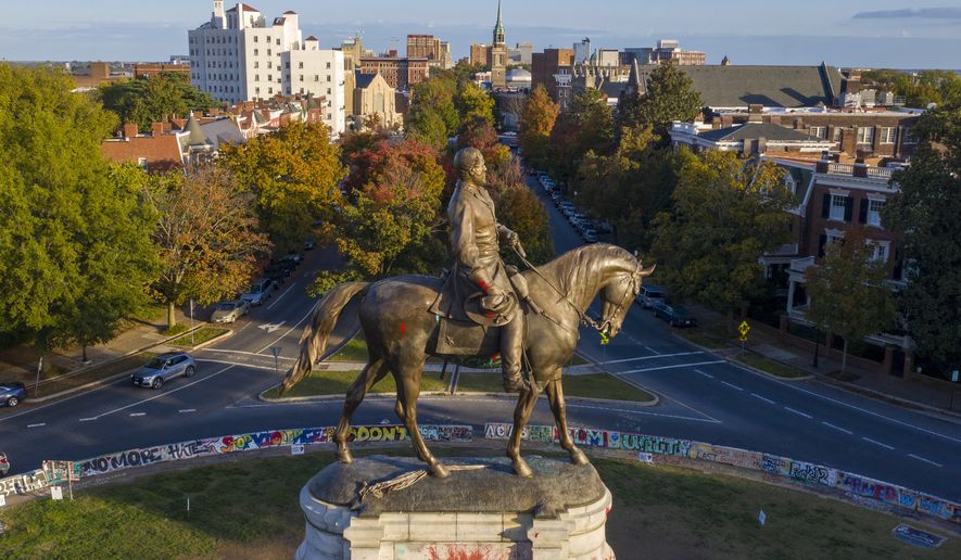 The afternoon sun illuminates the statue of Confederate General Robert E. Lee on Monument Ave in Richmond, Va., Monday, Oct. 19, 2020. A Richmond judge heard arguments in a lawsuit over the Governors&#39; order to remove the statue. (AP Photo/Steve Helber)