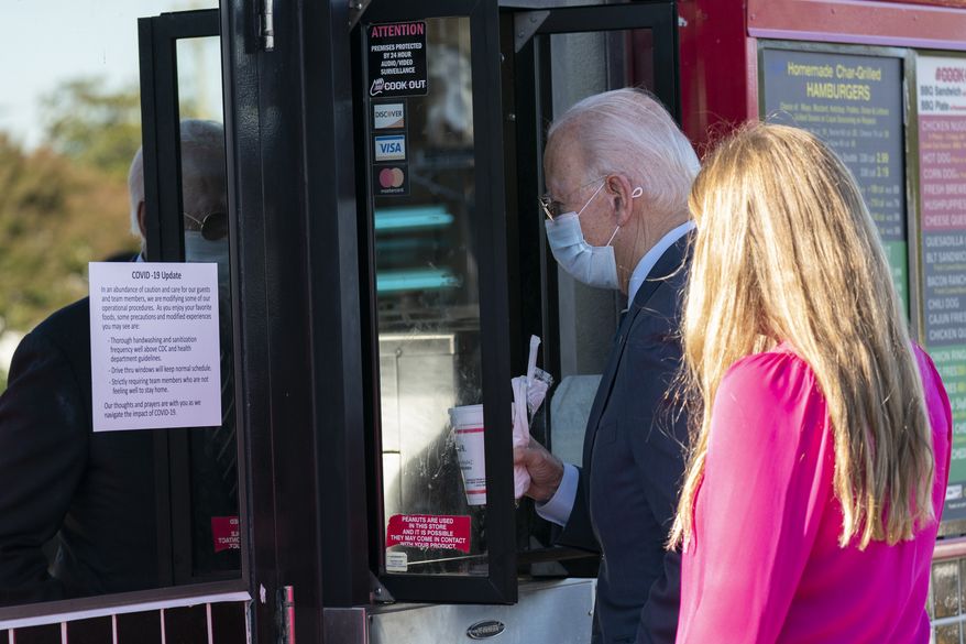 Democratic presidential candidate former Vice President Joe Biden and his granddaughter Finnegan order at window of Cook Out in Durham, N.C., Sunday, Oct. 18, 2020. (AP Photo/Carolyn Kaster)