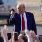 President Donald Trump points to a cheering crowd as he arrives for a campaign rally Monday, Oct. 19, 2020, in Tucson, Ariz. (AP Photo/Ross D. Franklin)