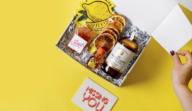 This product image shows citrus items in a gift box from HappyBoxStore.com. It&#x27;s filled with grapefruit gummy bears, orange blossom honey, a tangerine clove cocktail mixer, a lemon hydrating sheet face mask and more. (Happy Box via AP)
