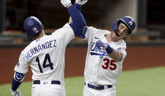 Los Angeles Dodgers&#x27; Cody Bellinger, right, celebrates his solo home run with Enrique Hernandez against Atlanta Braves relief pitcher Chris Martin during the seventh inning in Game 7 of a baseball National League Championship Series, Sunday, Oct. 18, 2020, in Arlington, Texas. (Curtis Compton/Atlanta Journal-Constitution via AP)