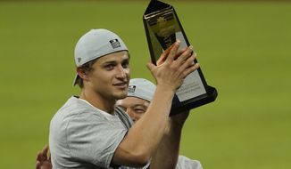 Los Angeles Dodgers shortstop Corey Seager celebrates with the MVP trophy after winning Game 7 of a baseball National League Championship Series against the Atlanta Braves Sunday, Oct. 18, 2020, in Arlington, Texas. (AP Photo/Eric Gay)