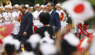 Japanese Prime Minister Yoshihide Suga, center right, and his Vietnamese counterpart Nguyen Xuan Phuc, center left, attend a welcoming ceremony at the Presidential Palace in Hanoi, Vietnam Monday, Oct. 19, 2020. (Kham/Pool Photo via AP)