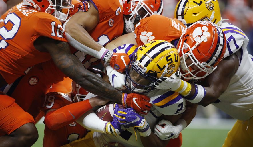 FILE - In this Jan. 13, 2020, file photo, LSU wide receiver Justin Jefferson is tackled by the Clemson defense during the first half of a NCAA College Football Playoff national championship game in New Orleans. The crunching hits, game-changing interceptions and dominating defense is the same for No. 1 Clemson. It's just the names that change from year to year. (AP Photo/Gerald Herbert, File)