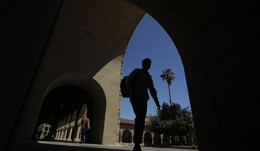 FILE - In this April 9, 2019, file photo, pedestrians walk on the campus at Stanford University in Stanford, Calif. The Education Department released a report Tuesday, Oct. 20, 2020, amid its effort to enforce a 1986 law requiring U.S. universities to disclose gifts and contracts from foreign sources. The department’s findings are primarily based on investigations it has opened at 12 schools, including Harvard, Yale, Stanford and Georgetown universities. (AP Photo/Jeff Chiu, File)