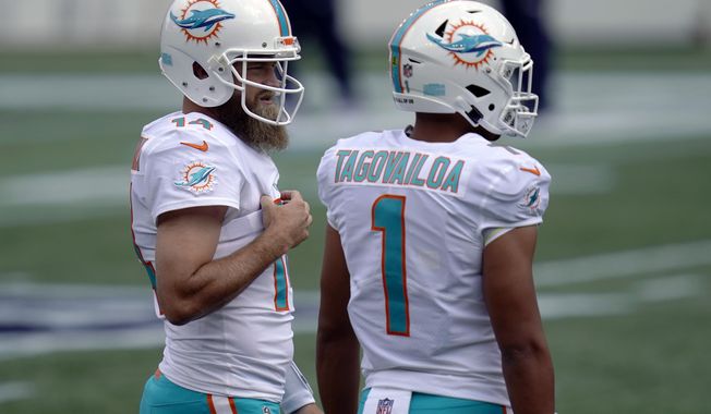 Miami Dolphins quarterbacks Ryan Fitzpatrick (14) and Tua Tagovailoa (1) warm up before an NFL football game against the New England Patriots, Sunday, Sept. 13, 2020, in Foxborough, Mass. (AP Photo/Charles Krupa)