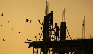 Indian laborers work at a building construction site in Gauhati, India, Monday, Oct. 19, 2020. (AP Photo/Anupam Nath)