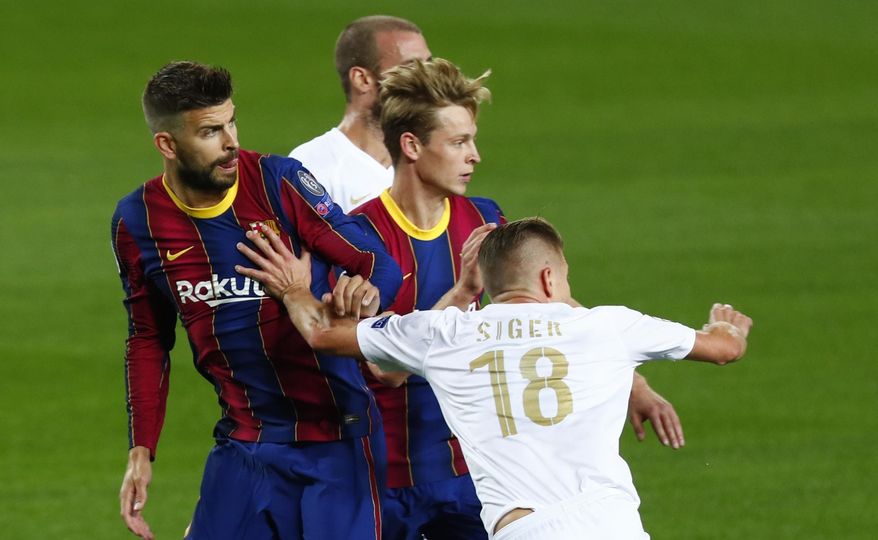 Ferencvaros' David Siger, right, pushes Barcelona's Gerard Pique during the Champions League group G soccer match between FC Barcelona and Ferencvaros at the Camp Nou stadium in Barcelona, Spain, Tuesday, Oct. 20, 2020. (AP Photo/Joan Monfort)