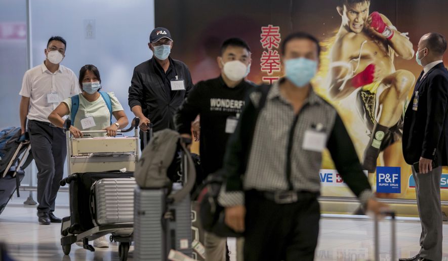Chinese tourists from Shanghai arrive at Suvarnabhumi airport on special tourist visas, in Bangkok, Thailand, Tuesday, Oct. 20, 2020. Thailand on Tuesday took a modest step toward reviving its coronavirus-battered tourist industry by welcoming 39 visitors who flew in from Shanghai, the first such arrival since normal traveler arrivals were banned almost seven months ago. (AP Photo/Wason Wanichakorn)