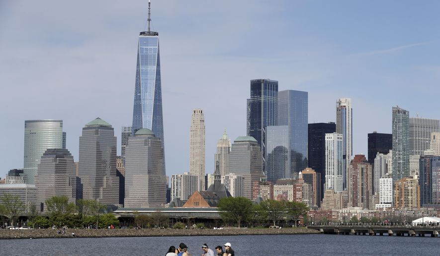 FILE - In this Saturday, May 2, 2020 file photo, people sit in view of Lower Manhattan at Liberty State Park in Jersey City, N.J. Rising cases of COVID-19 in the nation and Northeast may lead to New York, New Jersey and Connecticut re-thinking how they add other states to their quarantine list. Gov. Andrew Cuomo said he&#x27;ll release an update Wednesday to his plan that designates parts of New York City and suburban communities as hot spots where schools and nonessential businesses are closed. (AP Photo/Seth Wenig, File)