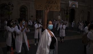 Medical residents take part in a protest against their working conditions during a strike in Barcelona, Spain, Tuesday, Oct. 20, 2020. Regional authorities across Spain continue to tighten restrictions against a sharp resurgence of coronavirus infections that is bringing the country’s cumulative caseload close to one million infections, the highest tally in western Europe. (AP Photo/Emilio Morenatti)