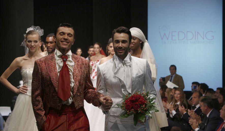 Models on the catwalk during a wedding fashion show with same-sex couples, dubbed "The rainbow wedding fashion show," part of a "wedding fair" taking place in Rome, Thursday, Oct. 23, 2014. Pope Francis endorsed same-sex civil unions for the first time as pope while being interviewed for the feature-length documentary Francesco, which premiered Wednesday, Oct. 21 2020, at the Rome Film Festival. (AP Photo/Domenico Stinellis)