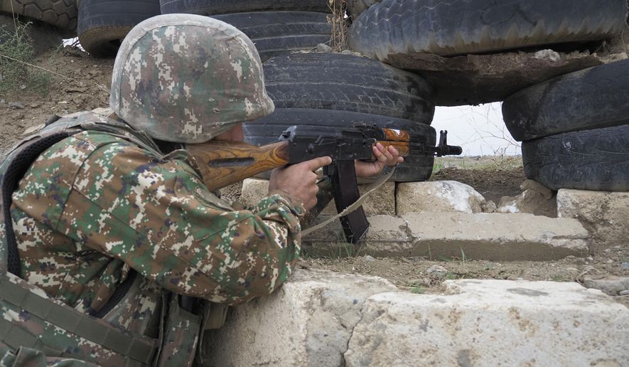 An Ethnic Armenian soldier holds a Kalashnikov machine gun as he looks toward Azerbaijan&#x27;s positions from a dugout at a fighting position on the front line, during a military conflict against Azerbaijan&#x27;s armed forces in the separatist region of Nagorno-Karabakh, Wednesday, Oct. 21, 2020. Armenia&#x27;s prime minister has urged citizens to sign up as military volunteers to help defend the country amid the conflict with Azerbaijan over the disputed territory of Nagorno-Karabakh as intense fighting has raged for a fourth week with no sign of abating. (AP Photo)