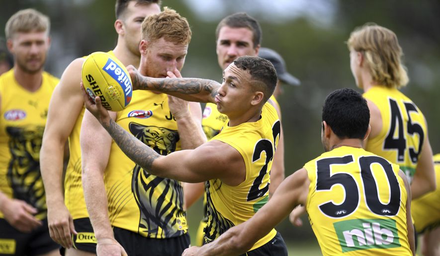 Richmond Tigers' Shai Bolton, center and teammates work out during a training at Metricon Stadium, in Gold Coast, Thursday, Oct. 22, 2020. The Australian Football League will have its grand final on Saturday at Brisbane in the so-called Sunshine State, ending more than a century of tradition. It has been moved from its regular home at the 100,000-capacity Melbourne Cricket Ground because of a coronavirus pandemic spike in Victoria state, where the top-flight grand final has been staged ever since the game of Aussie rules was invented. The Richmond Tigers play the Geelong Cats in Saturday's grand final. (Dave Hunt/AAP Image via AP)