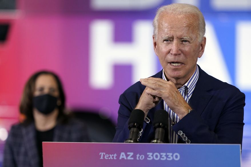 Democratic presidential candidate former Vice President Joe Biden speaks as Democratic vice presidential candidate Sen. Kamala Harris, D-Calif., listens at the Carpenters Local Union 1912 in Phoenix, Thursday, Oct. 8, 2020, to kick off a small business bus tour. (AP Photo/Carolyn Kaster) **FILE**
