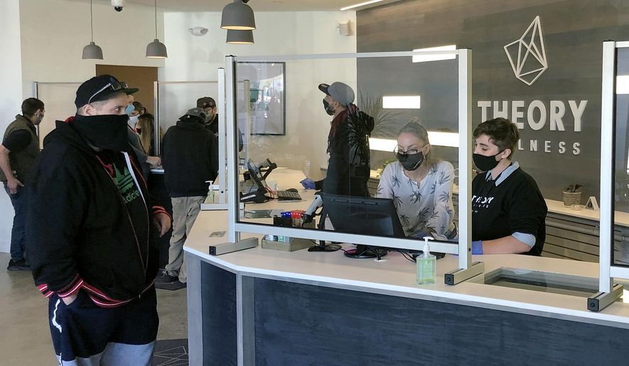 Buyers line up to purchase cannabis products at Theory Wellness on Friday, Oct. 9, 2020, in South Portland, Maine. Friday is the first day of legal marijuana sales for adult recreational use in the state. (AP Photo/David Sharp)