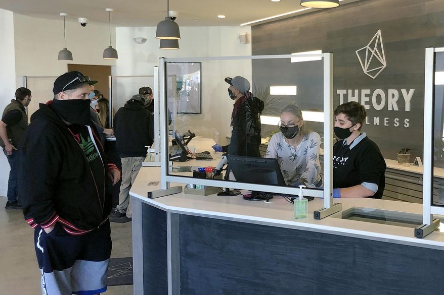 Buyers line up to purchase cannabis products at Theory Wellness on Friday, Oct. 9, 2020, in South Portland, Maine. Friday is the first day of legal marijuana sales for adult recreational use in the state. (AP Photo/David Sharp)