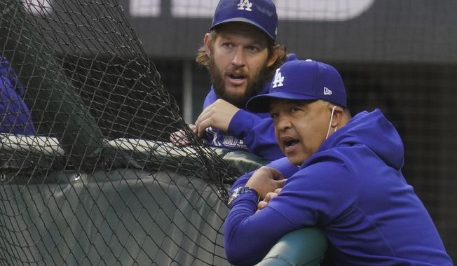 Los Angeles Dodgers manager Dave Roberts and starting pitcher Clayton Kershaw watch batting practice before Game 2 of the baseball World Series against the Tampa Bay Rays Wednesday, Oct. 21, 2020, in Arlington, Texas. (AP Photo/Sue Ogrocki)