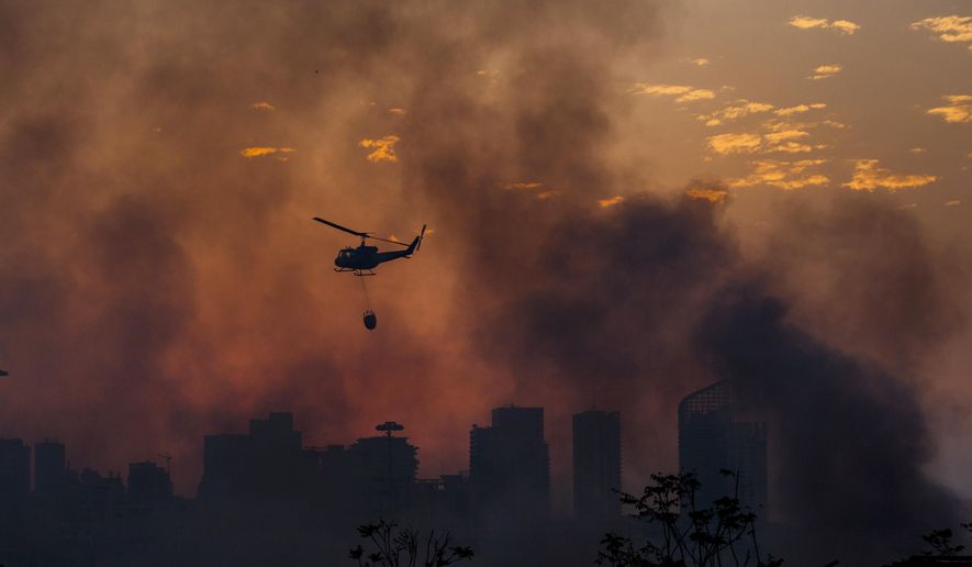 An army helicopter drops water on a fire at warehouses at the seaport in Beirut, Lebanon, Friday, Sept. 11, 2020. A huge fire has broken out Thursday, at the Port of Beirut, sending up a thick column of black smoke and raising new panic among traumatized residents after last month&#x27;s catastrophic blast. (AP Photo/Hassan Ammar)