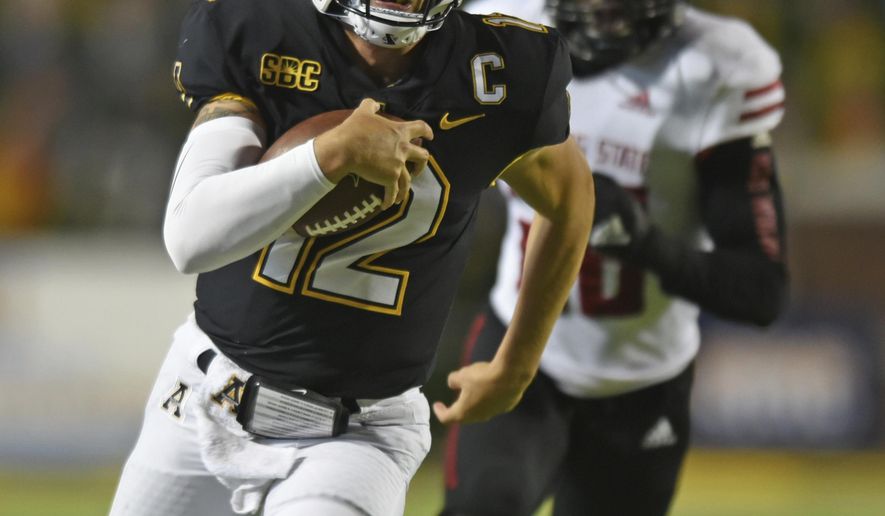 Appalachian State quarterback Zac Thomas, front, scrambles for a first down ahead of Arkansas State linebacker Jeffmario Brown in the first half of an NCAA college football game, Thursday, Oct. 22, 2020, at Kidd Brewer Stadium in Boone, N.C. (Walt Unks/Winston-Salem Journal via AP)
