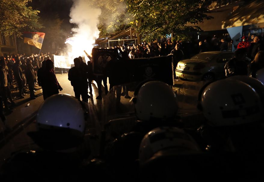 Serbian police officers guard the street during a protest against a festival ''Mirdita-Dobar Dan'' organized by liberal groups from Serbia and Kosovo, in Belgrade, Serbia, Thursday, Oct. 22, 2020. Serbian police prevented dozens of right-wing extremists from disrupting a youth cultural event with Kosovo after similar groups in the past weeks broke into a cartoon exhibition and threatened artists in a theatre play about the 1995 killings in Srebrenica. (AP Photo/Darko Vojinovic)