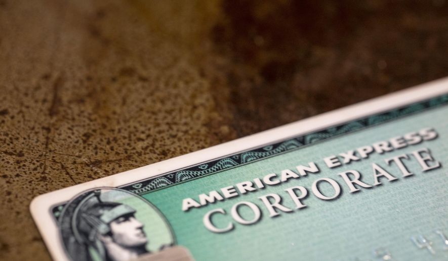 FILE - This Aug. 11, 2019 file photo shows an American Express card in New Orleans. American Express’ fourth-quarter profits dropped by 39%, the credit card giant said Friday, Oct. 23, 2020, as the pandemic’s deep impacts on travel, entertainment and dining dramatically impacted the company’s results. (AP Photo/Jenny Kane)