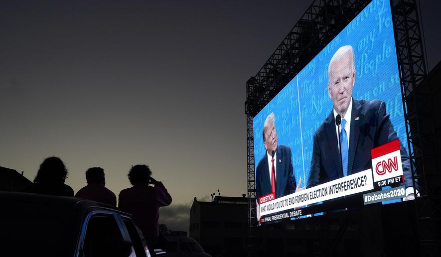 People watch from their vehicle as President Donald Trump, on left of video screen, and Democratic presidential candidate former Vice President Joe Biden speak during a Presidential Debate Watch Party at Fort Mason Center in San Francisco, Thursday, Oct. 22, 2020. The debate party was organized by Manny&#39;s, a San Francisco community meeting and learning place. (AP Photo/Jeff Chiu)