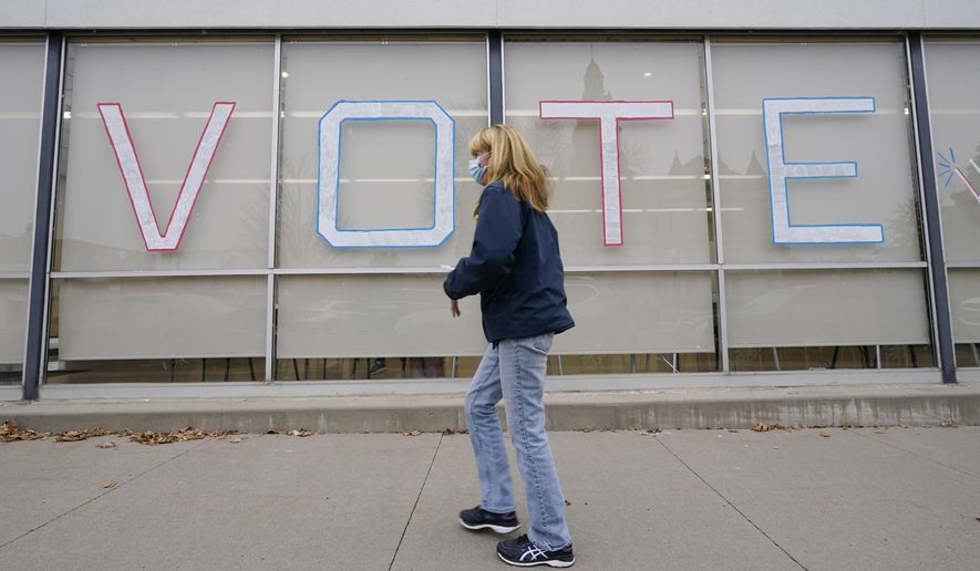 A local resident arrives to cast her ballot during early voting for the general election, Tuesday, Oct. 20, 2020, in Adel, Iowa. (AP Photo/Charlie Neibergall)