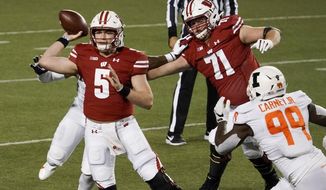 Wisconsin quarterback Graham Mertz throws a pass during the first half of an NCAA college football game against Illinois Friday, Oct. 23, 2020, in Madison, Wis. (AP Photo/Morry Gash)