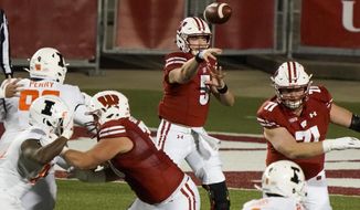 Wisconsin quarterback Graham Mertz throws a pass during the first half of an NCAA college football game against Illinois Friday, Oct. 23, 2020, in Madison, Wis. (AP Photo/Morry Gash)
