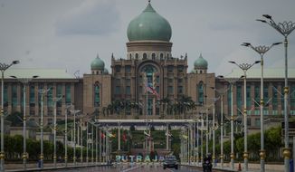 Motorists drive in front of the prime minister&#39;s office building in Putrajaya, Malaysia, Friday, Oct. 23, 2020. Malaysian opposition leader Anwar Ibrahim said Friday he was concerned about reports that Prime Minister Muhyiddin Yassi may invoke emergency laws to suspend Parliament and stymie bids to oust his government. (AP Photo/Vincent Thian)