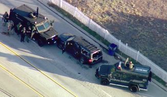 FILE - In this Dec. 2, 2015 file photo from video, armored vehicles surround an SUV following a shootout in San Bernardino, Calif. Enrique Marquez Jr., who bought two rifles that a husband and wife used to kill 14 people in a California terror attack is expected to be sentenced.  He is scheduled to appear in federal court Friday, Oct. 23, 2020 in Riverside.  (KTTV-TV via AP, File)