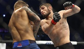 FILE - In this Sept. 7, 2019, file photo, Russia&#39;s Khabib Nurmagomedov, right, fights with Dustin Poirier, of Lafayette, La., during a lightweight title mixed martial arts bout at UFC 242 in Yas Mall in Abu Dhabi, United Arab Emirates. Nurmagomedov will risk his unbeaten record and his UFC lightweight title against interim champion Justin Gaethje in the main event of UFC 254 in Abu Dhabi on Saturday, Oct. 24, 2020. (AP Photo/Mahmoud Khaled, File)