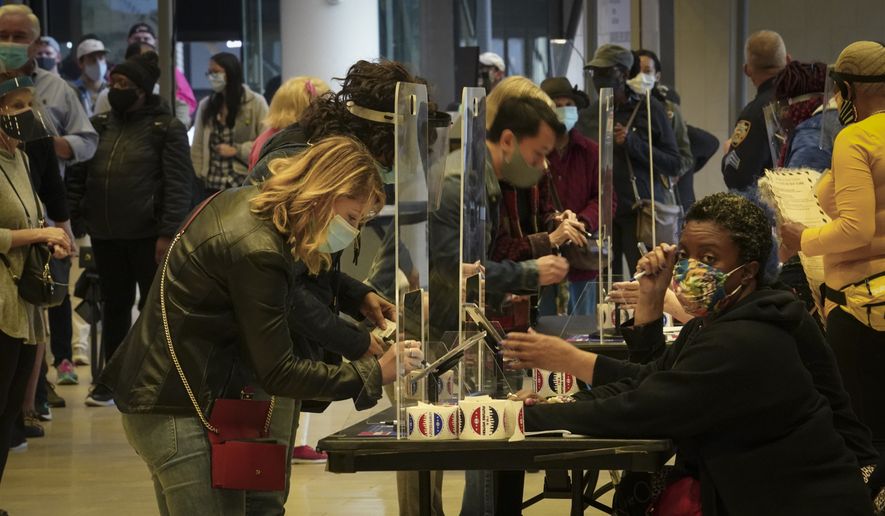 Voters sign in to cast votes at the Madison Square Garden's early voting polling site, Saturday Oct. 24, 2020, in New York. (AP Photo/Bebeto Matthews)