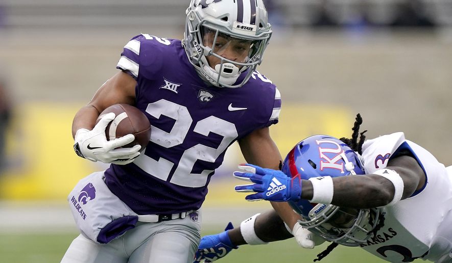 Kansas State running back Deuce Vaughn (22) gets past Kansas safety Ricky Thomas (3) as he runs for a first down during the first half of an NCAA football game Saturday, Oct. 24, 2020, in Manhattan, Kan. (AP Photo/Charlie Riedel)