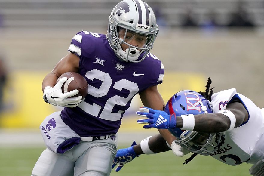 Kansas State running back Deuce Vaughn (22) gets past Kansas safety Ricky Thomas (3) as he runs for a first down during the first half of an NCAA football game Saturday, Oct. 24, 2020, in Manhattan, Kan. (AP Photo/Charlie Riedel)