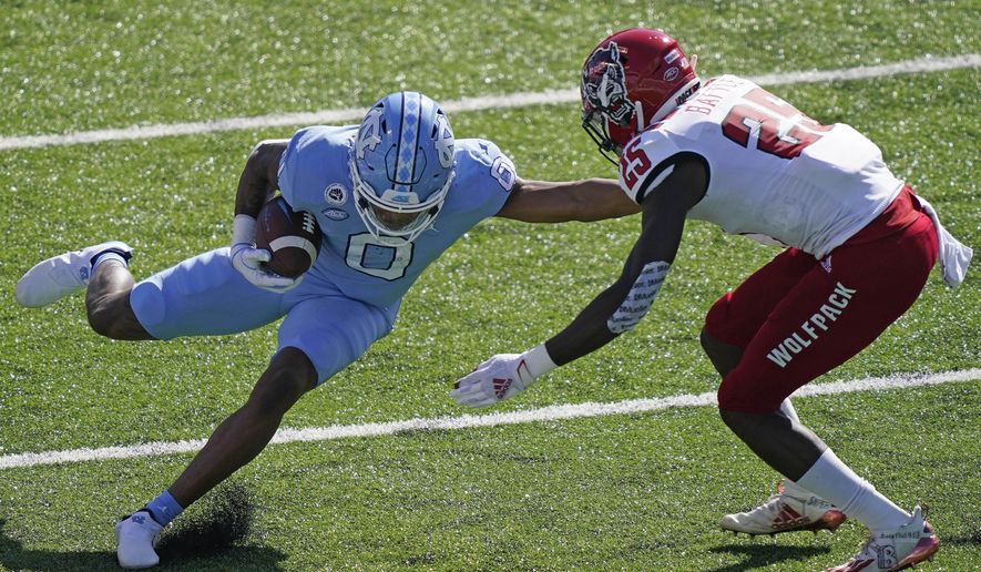 North Carolina wide receiver Emery Simmons (0) runs the ball while North Carolina State cornerback Shyheim Battle (25) looks to tackle during the first half of an NCAA college football game in Chapel Hill, N.C., Saturday, Oct. 24, 2020. (AP Photo/Gerry Broome)