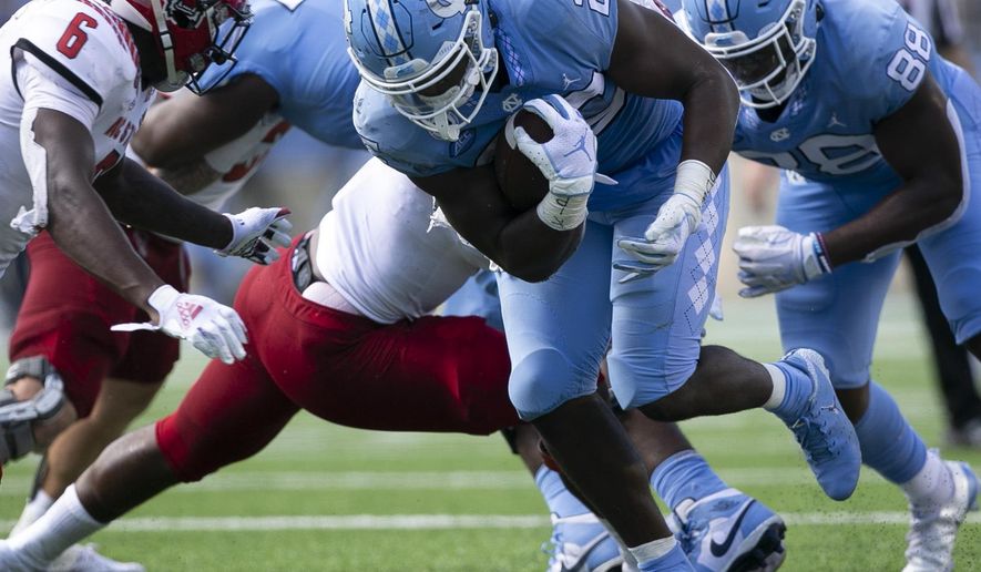 North Carolina's Javonte Williams (25) rushes for a first down against N.C. State in the first half of an NCAA college football game on Saturday, Oct. 24, 2020 in Chapel Hill, N.C. (Robert Willett/The News & Observer via AP)
