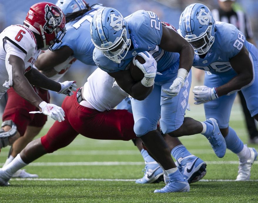 North Carolina's Javonte Williams (25) rushes for a first down against N.C. State in the first half of an NCAA college football game on Saturday, Oct. 24, 2020 in Chapel Hill, N.C. (Robert Willett/The News & Observer via AP)