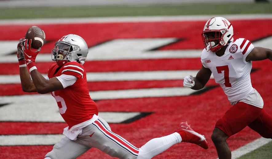 Ohio State receiver Garrett Wilson, left, catches a touchdown pass past Nebraska defensive back Dicaprio Bootle during the first half of an NCAA college football game Saturday, Oct. 24, 2020, in Columbus, Ohio. (AP Photo/Jay LaPrete)