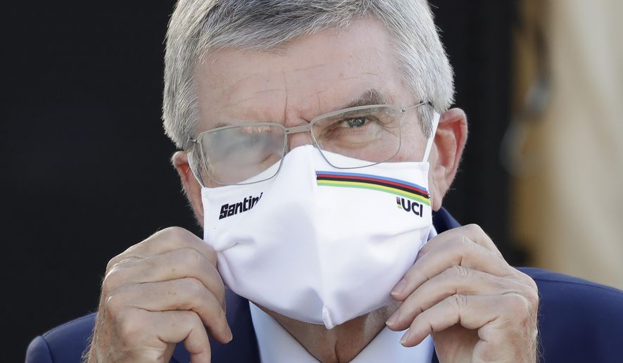 IOC President Thomas Bach waits for the podium ceremony for the women&#x27;s elite event at the road cycling World Championships in Imola, Italy on Sept. 26, 2020. Organizers of a South Korean award say International Olympic Committee President Thomas Bach has decided not to visit in person this week and accept the prize because of concerns about the coronavirus pandemic. Bach was named winner of the Seoul Peace Prize last month and was to receive the award on Monday, Oct. 26, 2020. (AP Photo/Andrew Medichini)