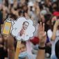 Pro-democracy activists display a placard with Thai Prime Minister Prayuth Chan-ocha&#x27;s head attached to a cockroach during a protest outside remand prison, in which some of the activists are kept, in Bangkok, Thailand, Friday, Oct. 23, 2020. Thailand&#x27;s government on Thursday canceled a state of emergency it had declared last week for Bangkok in a gesture offered by the embattled prime minister to cool student-led protests seeking democracy reforms. (AP Photo/Sakchai Lalit)