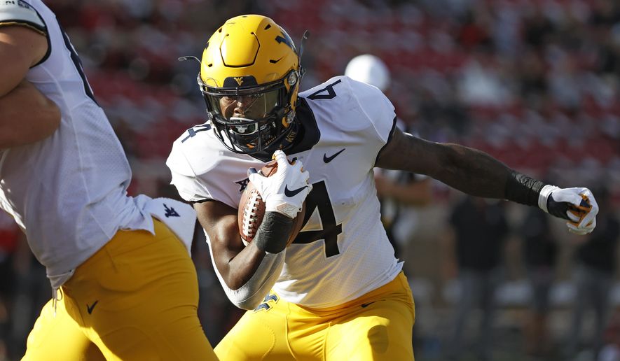 West Virginia's Leddie Brown (4) runs the ball to score a touchdown during the first half of an NCAA college football game against Texas Tech, Saturday, Oct. 24, 2020, in Lubbock, Texas. (AP Photo/Brad Tollefson)