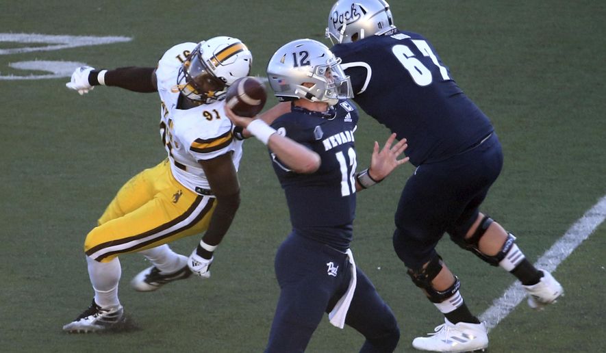 Nevada quarterback Carson Strong (12) throws a touchdown pass against Wyoming State during the first half of an NCAA college football game Saturday, Oct. 24, 2020, in Reno, Nev. (AP Photo/Lance Iversen)