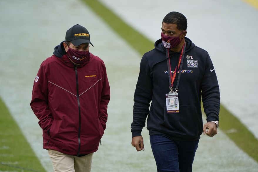 Washington Football Team owner Dan Snyder, left, and team president Jason Wright, right, walk off the field before the start of the first half of an NFL football game against Dallas Cowboys, Sunday, Oct. 25, 2020, in Landover, Md. (AP Photo/Susan Walsh) ** FILE **