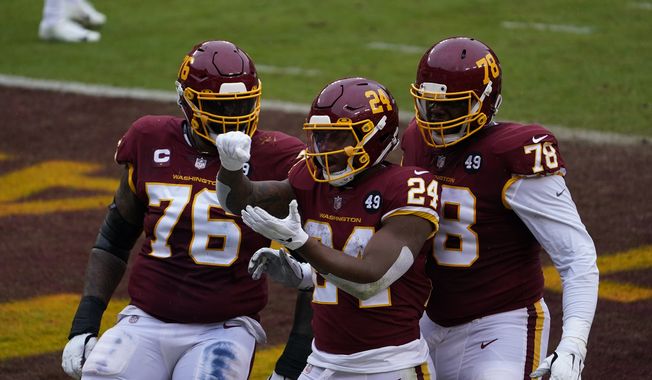 Washington Football Team running back Antonio Gibson (24) celebrating his touchdown with teammates offensive tackle Morgan Moses and offensive tackle Cornelius Lucas (78) in the first half of an NFL football game, Sunday, Oct. 25, 2020, in Landover, Md. (AP Photo/Susan Walsh) ** FILE **